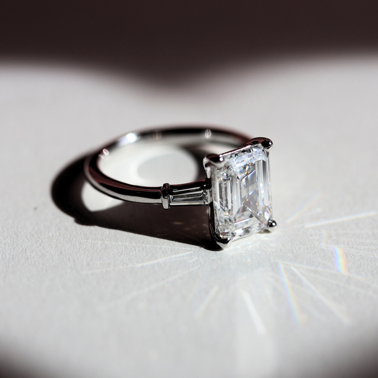 Anillo de Compromiso con Diamante central corte Esmeralda y trapecios en Oro Blanco 14k